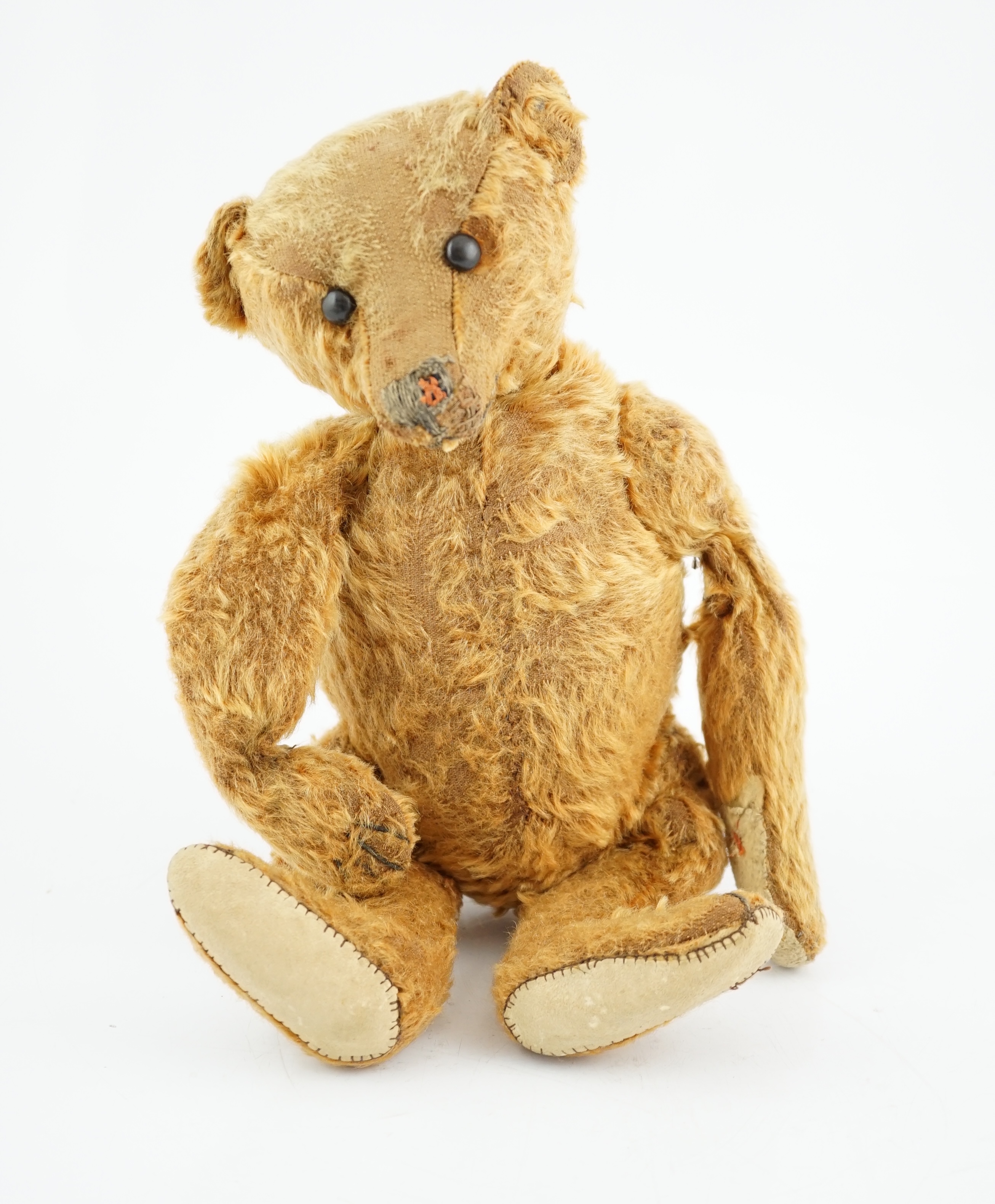 A cinnamon Steiff bear c.1908, with button paw pads, stuffing missing in arms, hair loss to head, muzzle repaired, general hair loss, 41cm